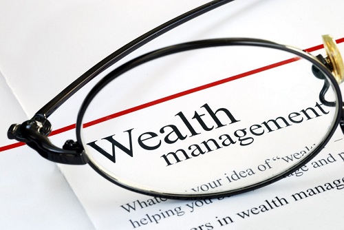 A printed page with the title' Wealth management' visible under a pair of spectacles