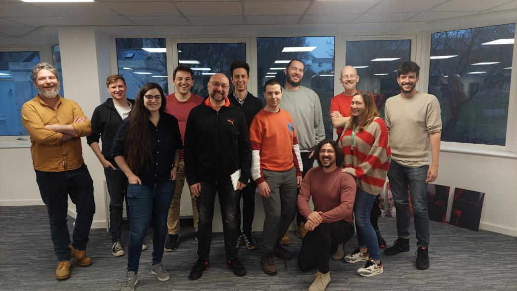 A group of 12 people standing and smiling.