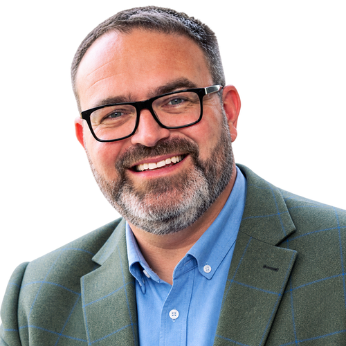 “Professional headshot of Barry Pridmore, founder of Pridmora Ltd, smiling and wearing glasses, a blue shirt and green blazer.”