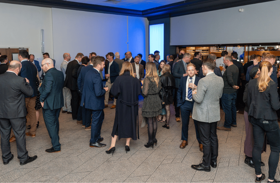 people standing with drinks while networking 