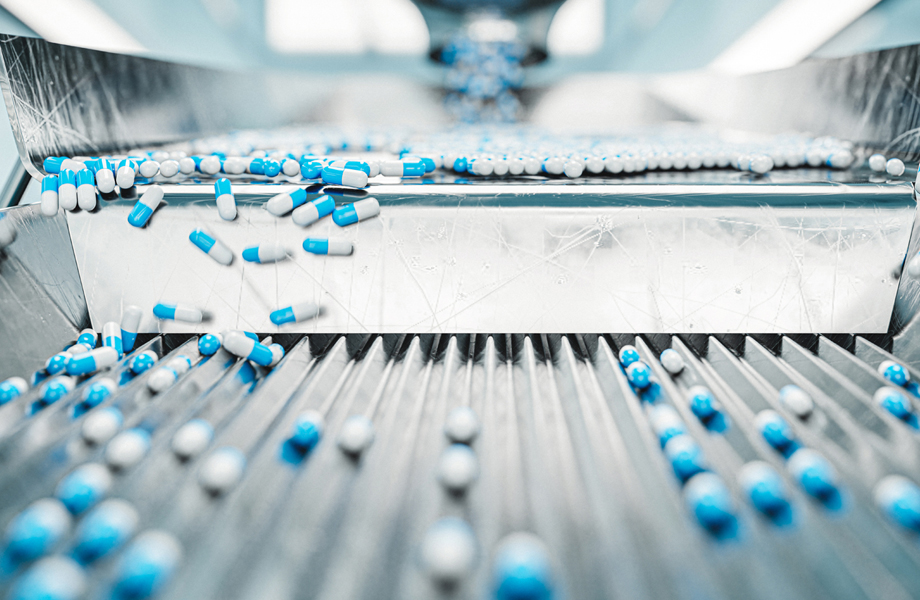 Filled pharmaceutical capsules moving along a production line. 