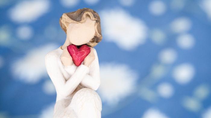 faceless 'angel' character holding a heart