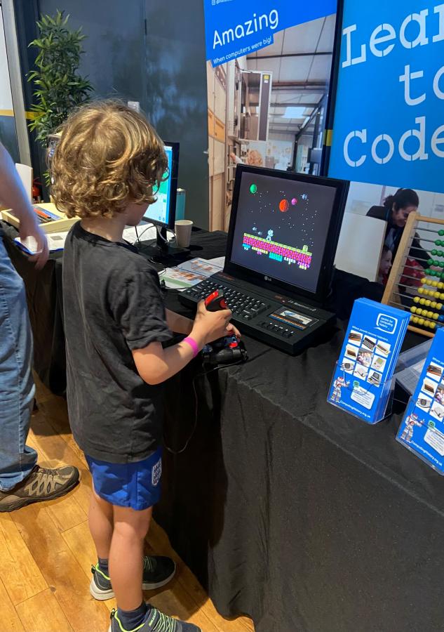 A young boy plays on a 1980s 8-bit computer game at a Centre for Computing History outreach event