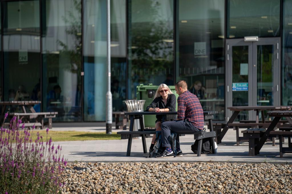 2 people sitting at a table outside
