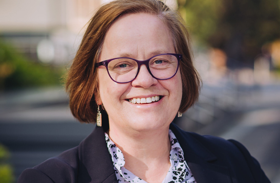 Headshot of a person wearing glasses outside