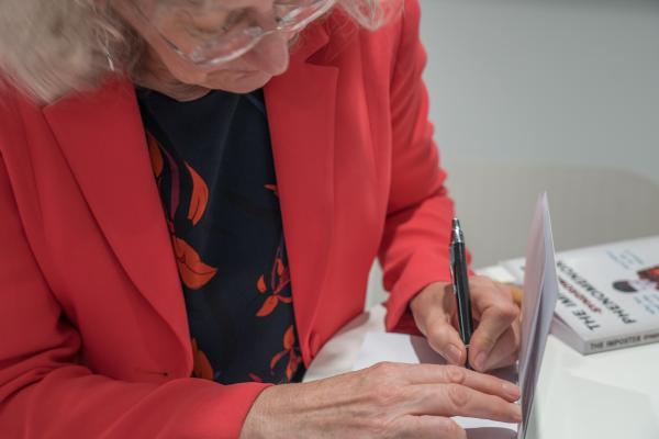 Kate Atkin signing copies of her book The Imposter Phenomenon