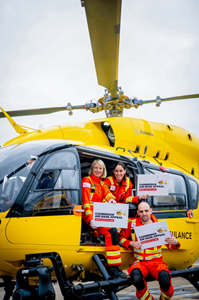 Yellow helicopter with three people with appeal signs