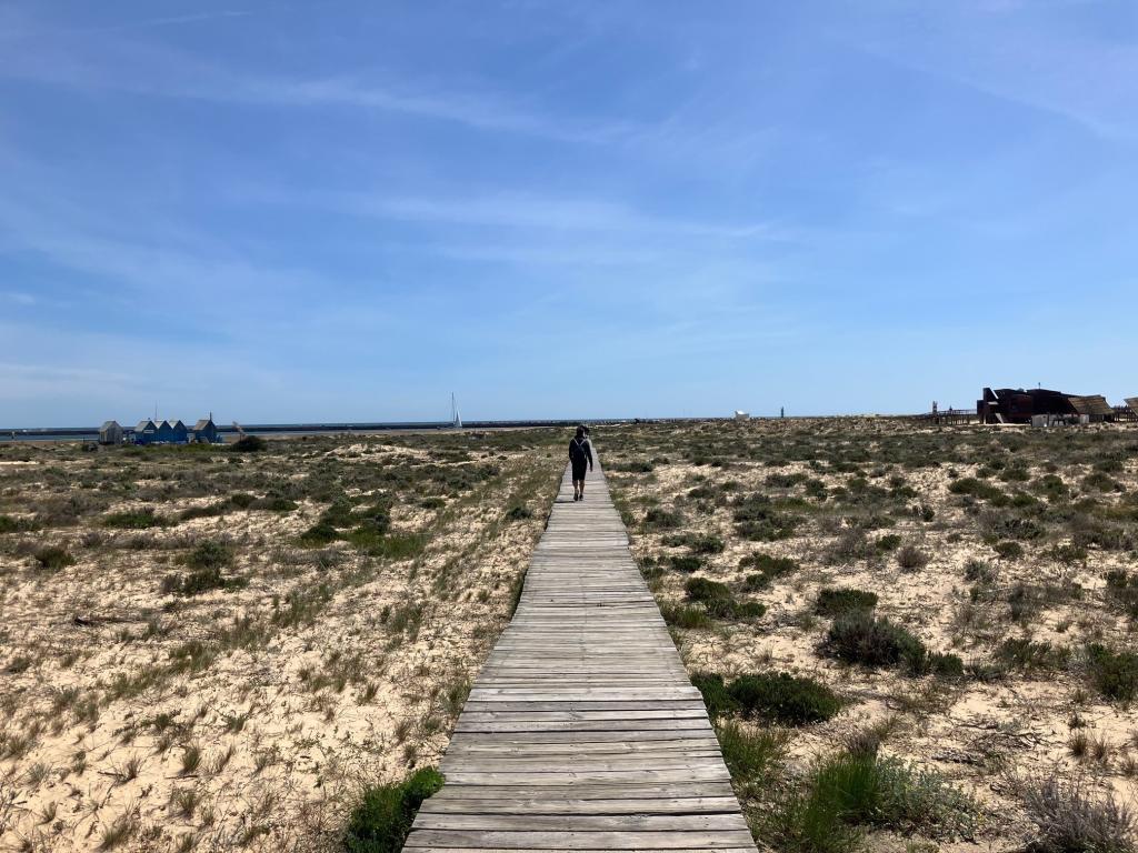 A man walking across a beautiful beach
