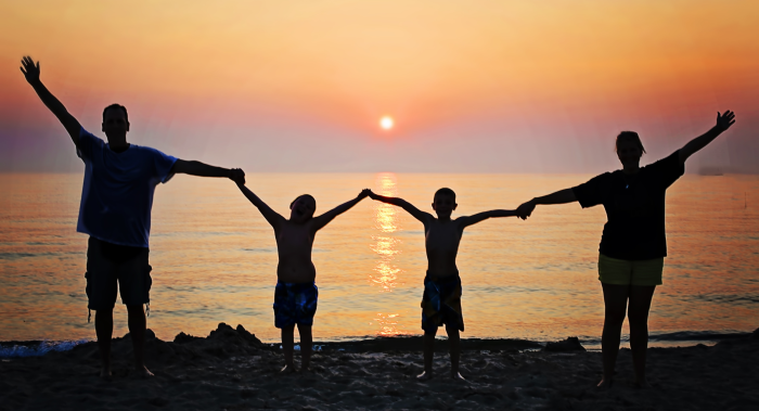 a family of 4 enjoying the sunset 