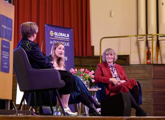 Sarah Hawkes, Laura Bates and Raewyn Connell sat on a stage at an event, Global 50/50 in Dialogue. 