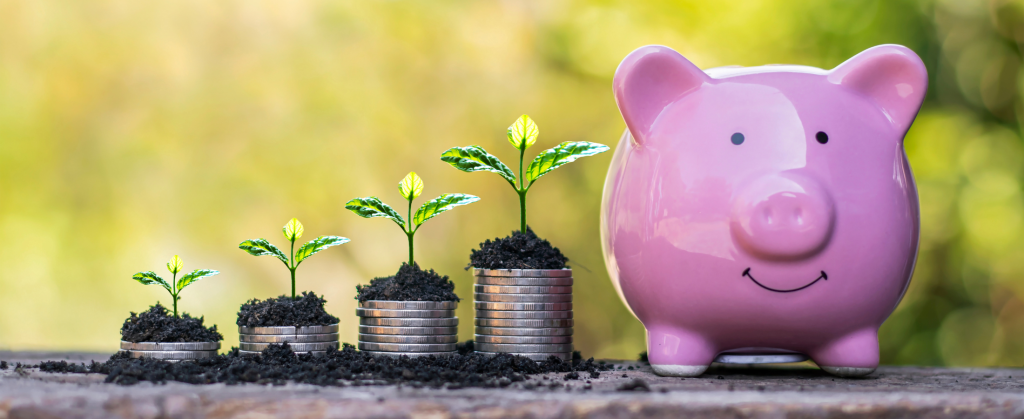 stack of coins sprouting plants next to a piggy bank