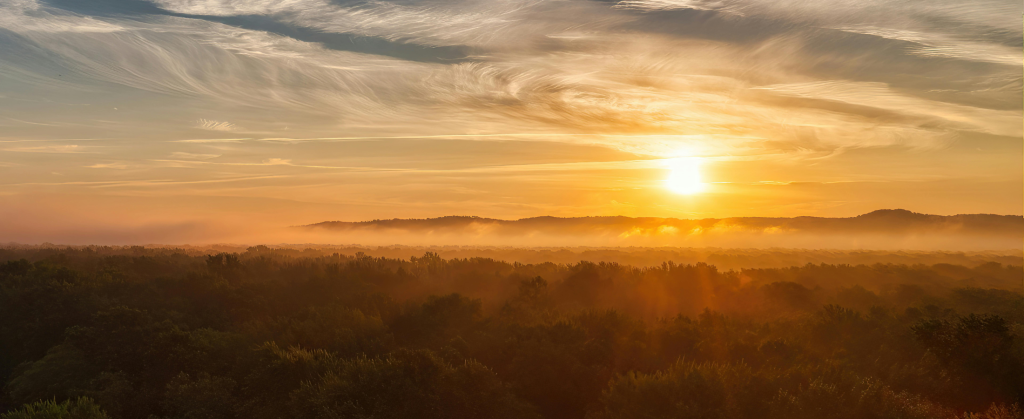 The sunset over the hills and fields