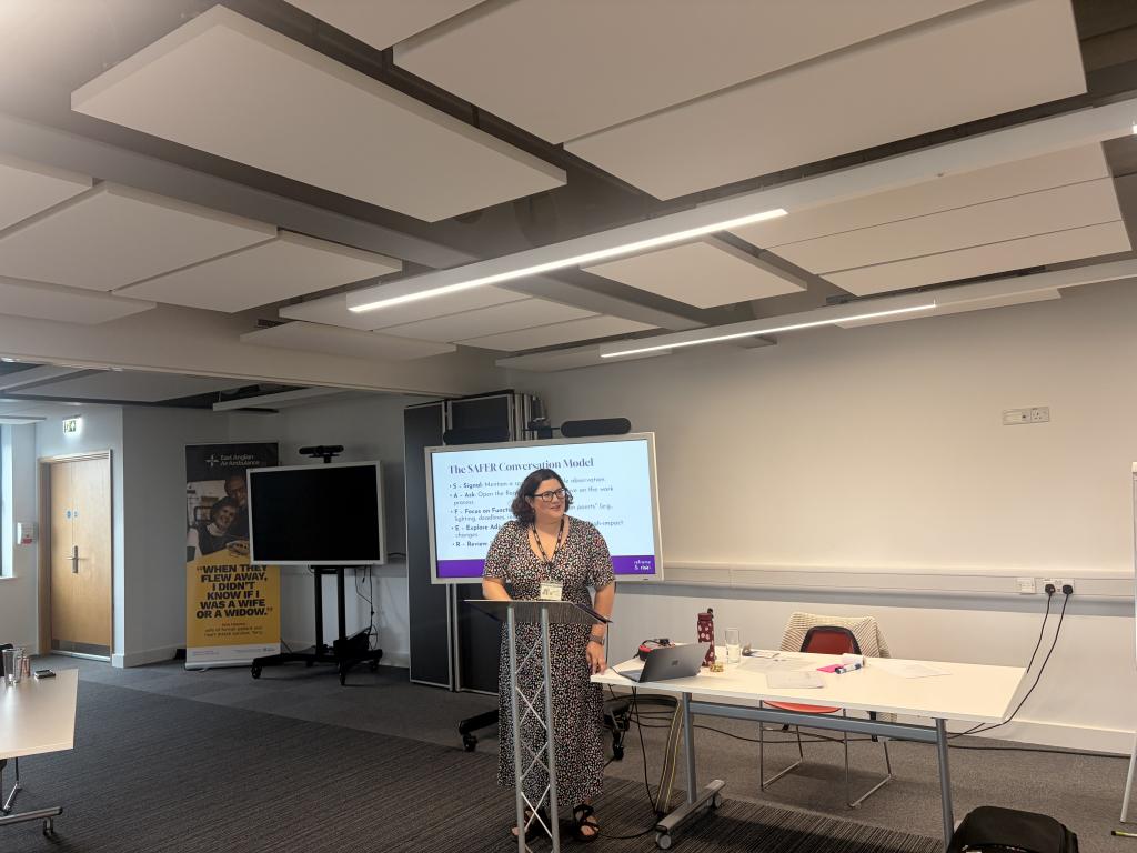 Sarah our trainer delivering line management training stood at podium with the SAFER conversation model behind