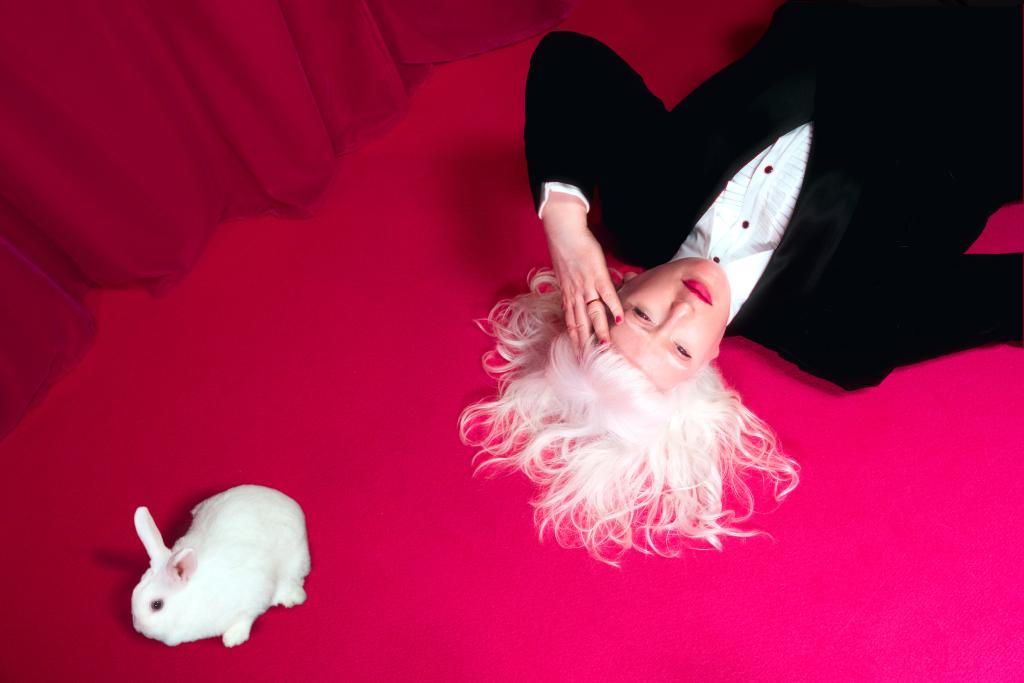 a lady on the floor with a white rabbit 