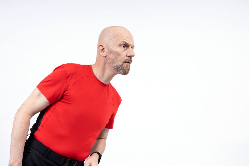 A bald man in a red t-shirt.