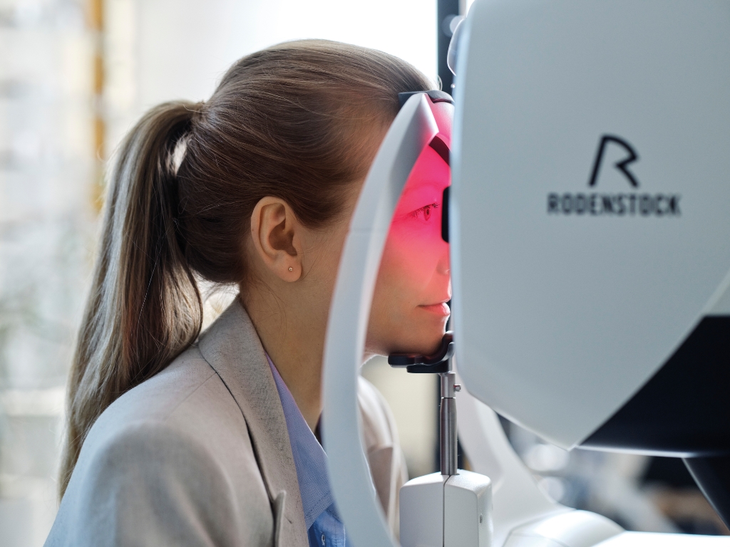 Female patient using Rodenstock eye scanner during eye exam