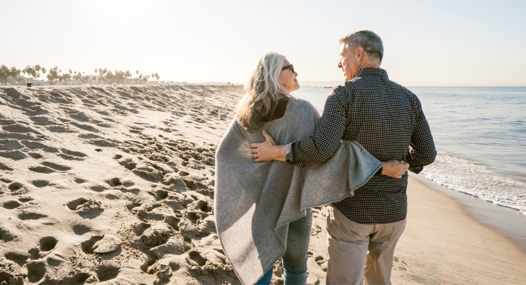 A man and woman walking on the beach