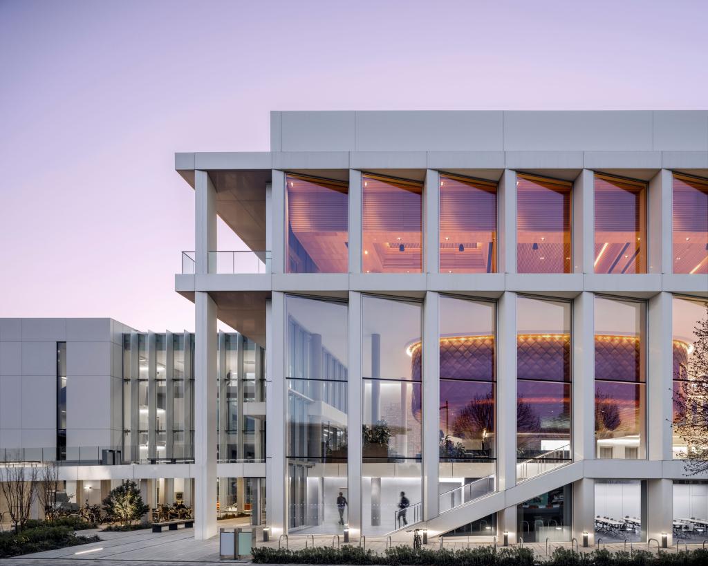 The white exterior of the Ray Dolby Centre with floor to ceiling windows over 3 floors. Now bookable for events via Meet Cambridge