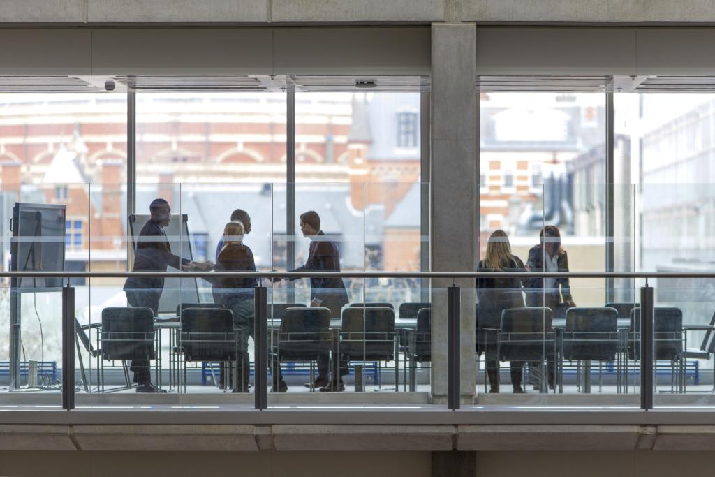 People shake hands in a meeting room