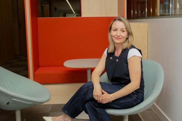 Photo of Kate Waters sitting on a chair in an office environment 