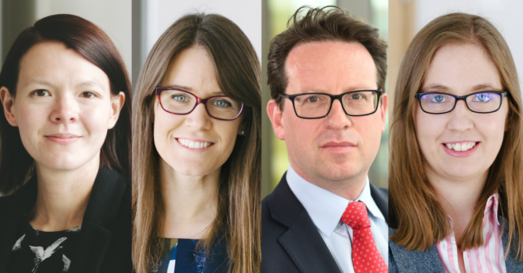 Four headshots in a line. Lady 1 has short dark hair. Lady 2 has glasses and long brown hair. Man with a red tie and glasses. Lady 3 has lighter hair with square glasses.