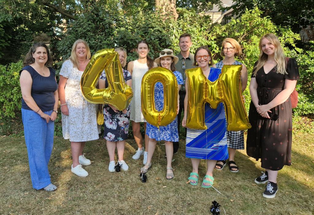 Staff team celebrating the milestone, holding up '40m' balloons