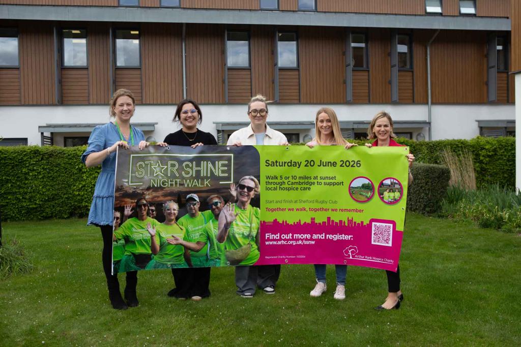 5 females holding a large banner outside 