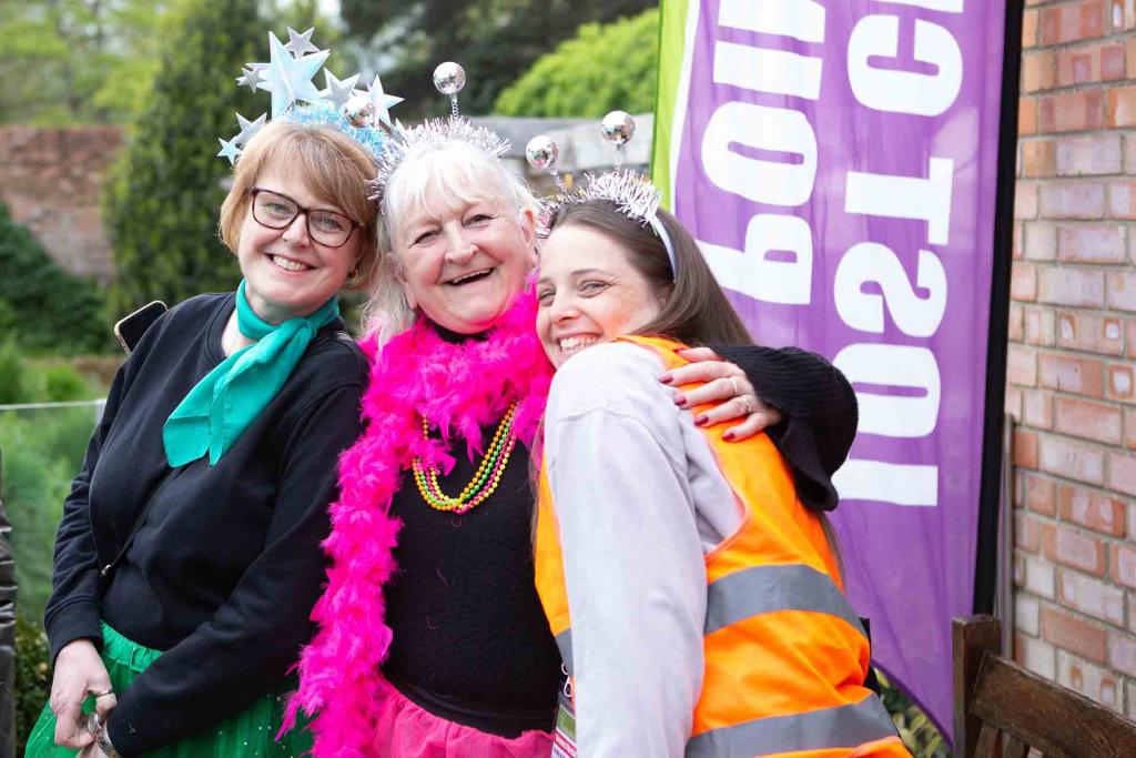 3 females dressed in bright colours smiling 
