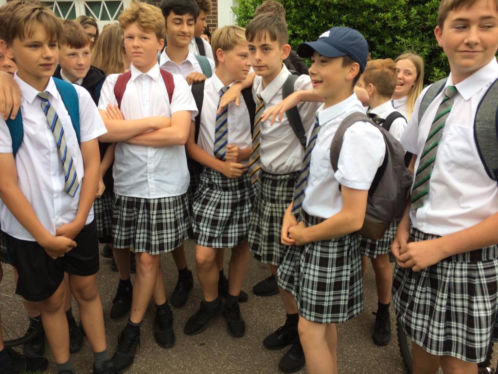 Group of schoolboys wearing skirts in protest at not being allowed to wear shorts in hot weather