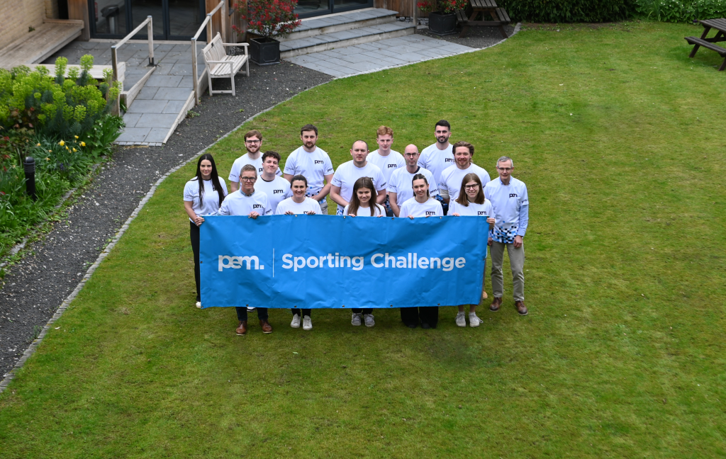 A group of people behind a banner in a garden