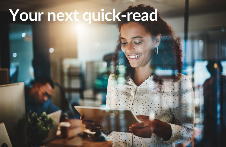 A woman reads news on her tablet looking delighted