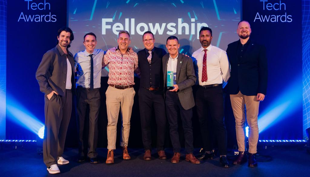 Fellowship team on stage receiving an award at the UK Business Tech Awards for digital agency of the year.
