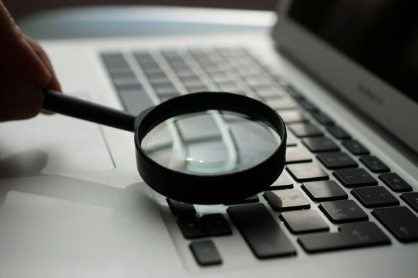 a laptop with a magnifying glass over the keys