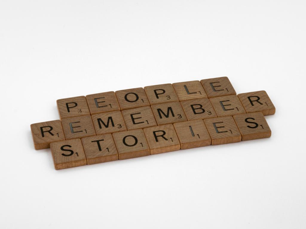 Wooden scrabble letters spelling out 'People remember stories'