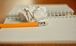 Image showing a chewed pencil, notepad and screwed up sheet of paper