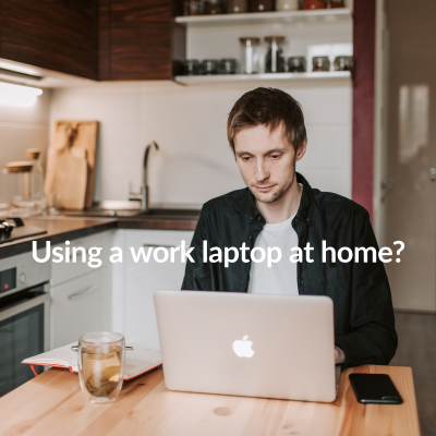 man using his work laptop at home on the kitchen table