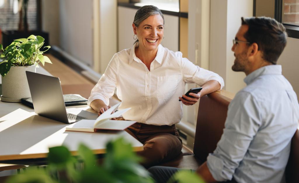 Two colleagues sit next to each other in an office environments