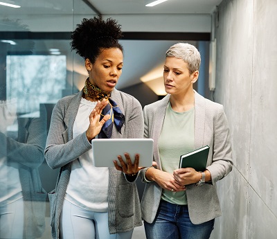 Two women walking down a workplace corridor