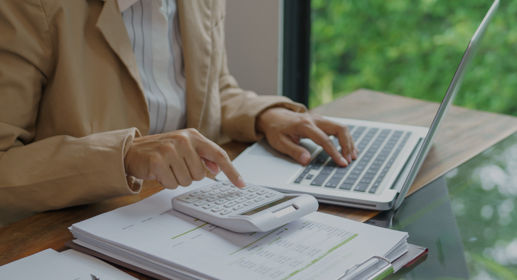 A woman doing her taxex online using a calculator