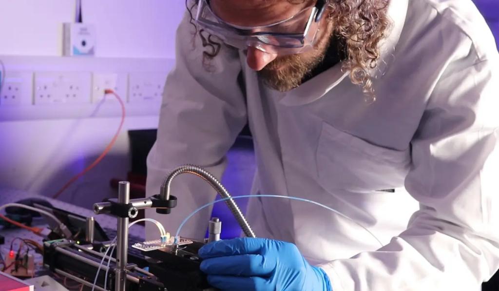 technician in lab coat with low-cost, label-free cell sorter prototype device