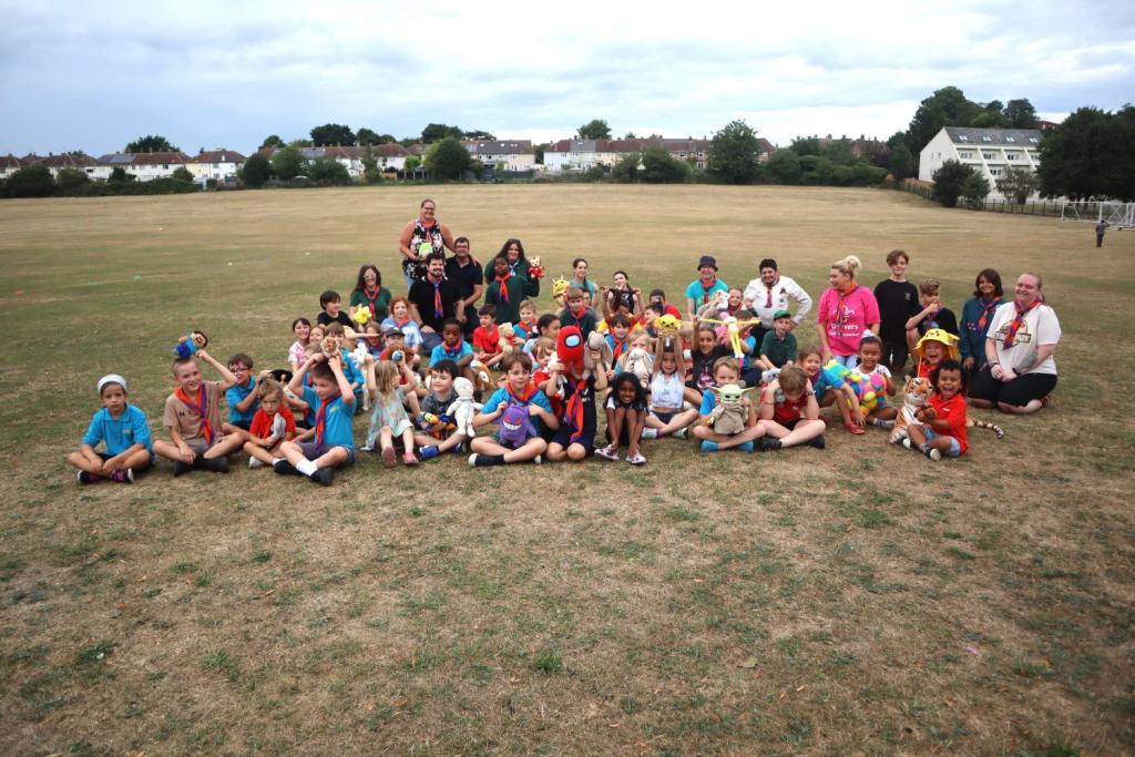 2nd Newmarket Scout Group sat together in a field looking at the camera