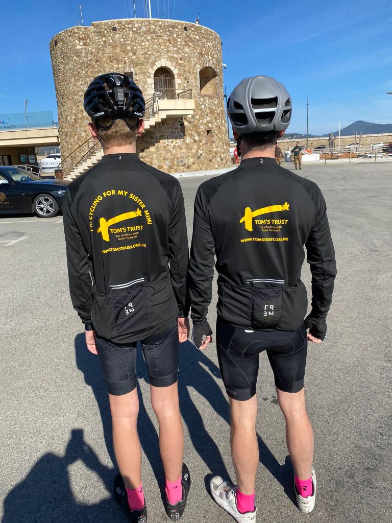 Before the race with backs against the camera in Tom's Trust cycling shirts