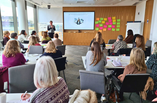 A Cambridge Network peer group: professionals listening to a talk in a room