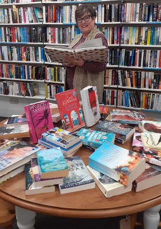 Retail volunteer surrounded by books