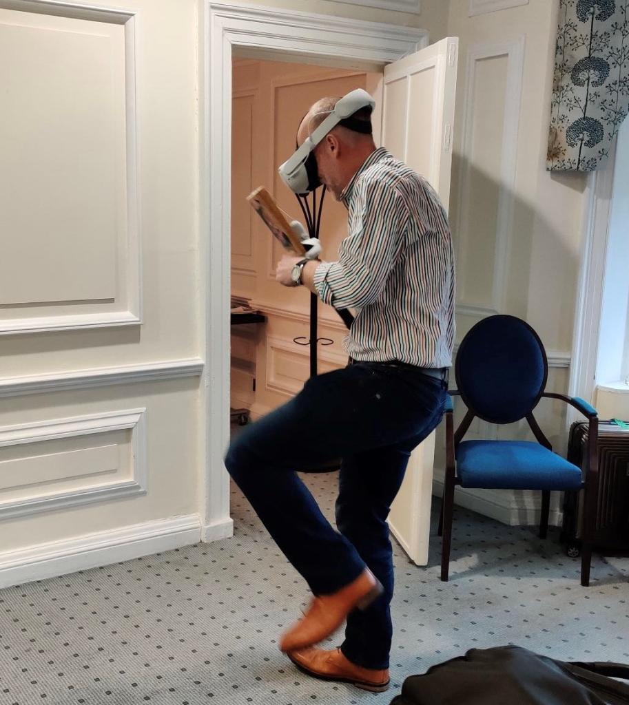 Simon playing cricket shot in VR headset