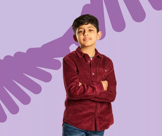 Child with arms crossed wearing a red shirt, with a purple background.
