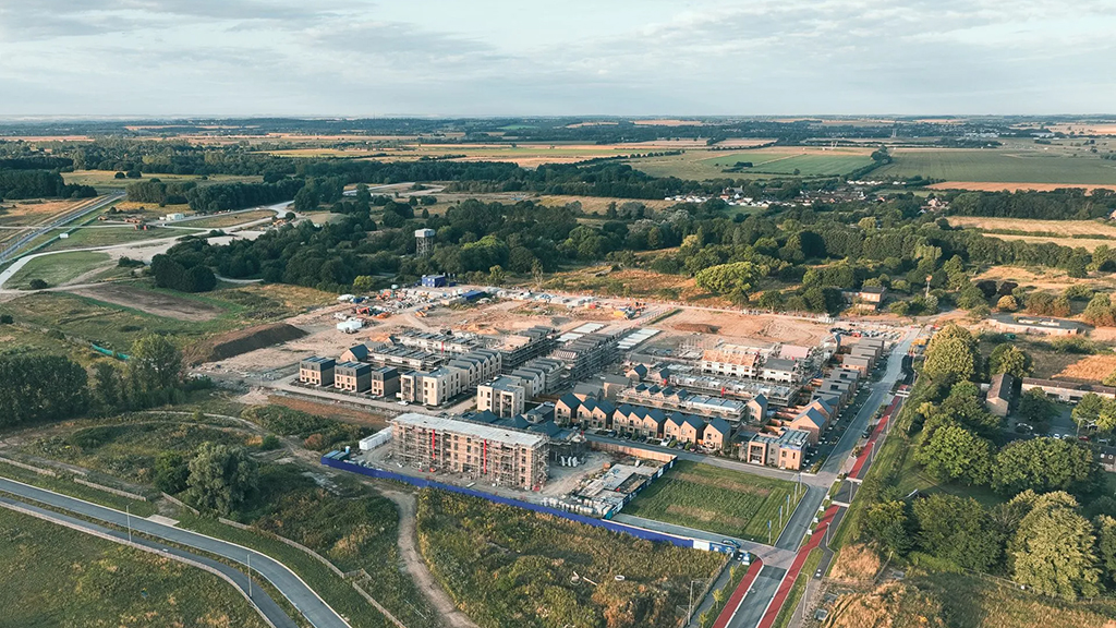 Aerial view of the Keepmoat residential construction site in Northstowe surrounded by fields, roads, and trees.