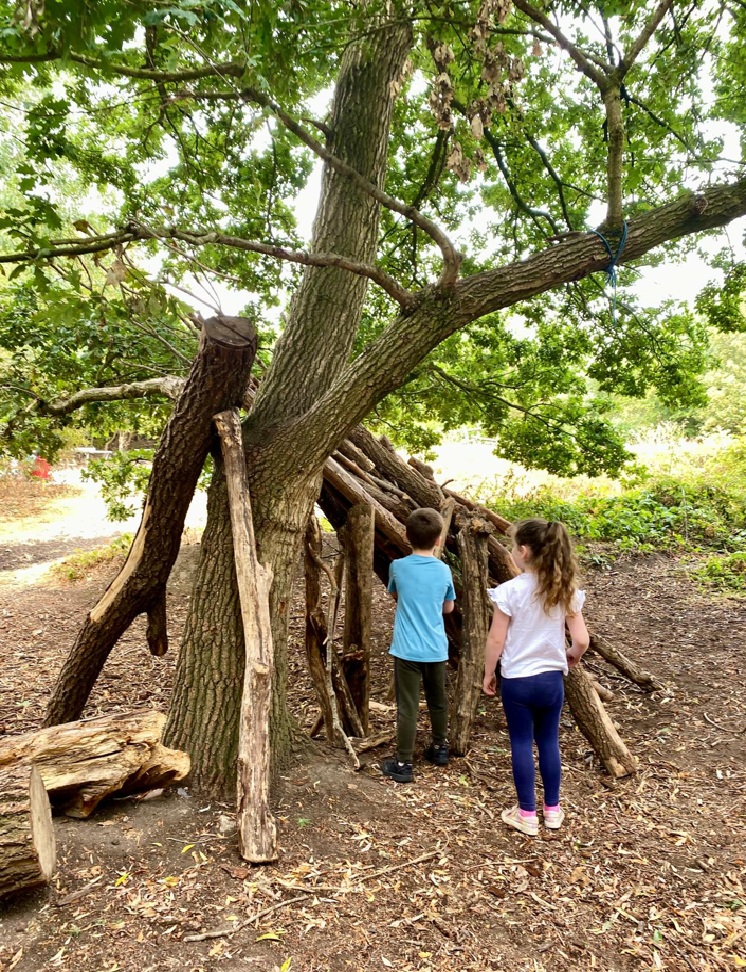 Two children building a den from logs