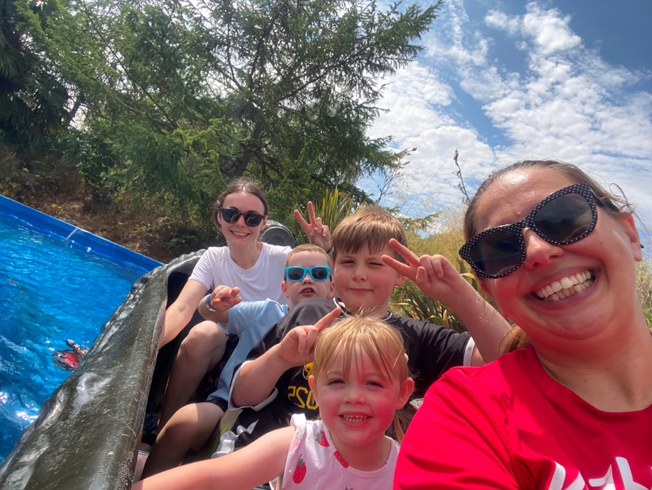One adult woman and four children on log flume ride