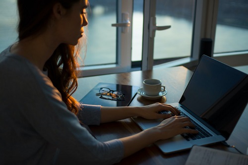 Woman sitting at laptop writing